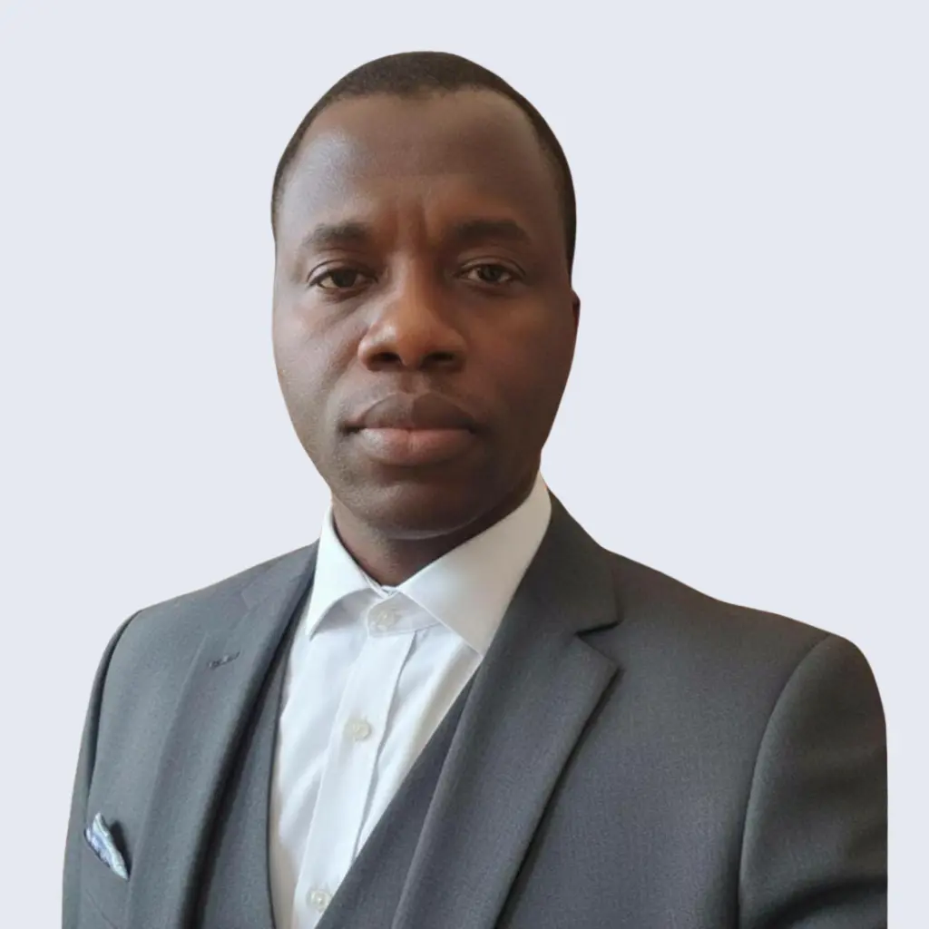 Portrait of Saheed Salami, Chief Operating Officer at BV Integrated Ltd, wearing a grey suit with a plain background.